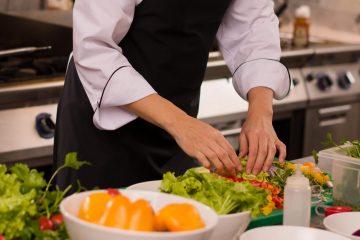 Chef,Serving,Vegetable,Salad,On,Plate,In,Restaurant,Kitchen