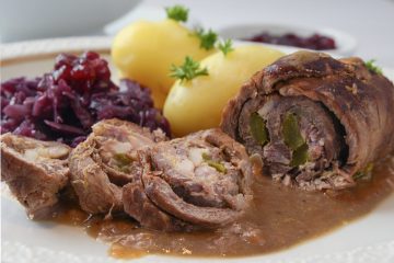 beef roulade with red cabbage, potatoes and sauce, german meat roll stuffed with cucumbers and bacon,  close up, selected focus, narrow depth of field
